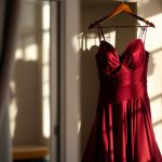 une-robe-de-soiree-elegante-suspendue-a-un-cintre-de-couleur-bordeaux-dans-une-piece-de-dressing-chaleureusement-eclairee