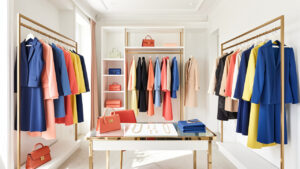 Dressing féminin lumineux présentant des vêtements coordonnés, des accessoires sobres et des touches colorées dans une mise en scène éditoriale élégante.